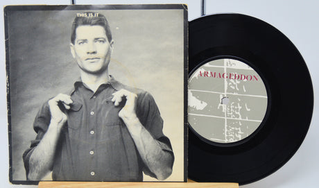 Vinyl record with a cover featuring a person and text 'This is it Armageddon'.