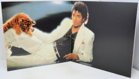 Person in a white outfit with a tiger on a dark background