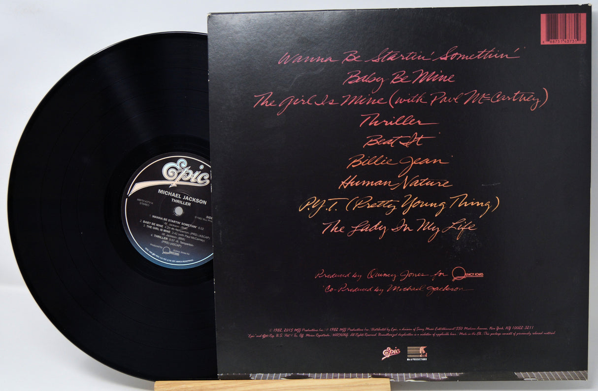 Vinyl record with a black cover featuring red text on a white background