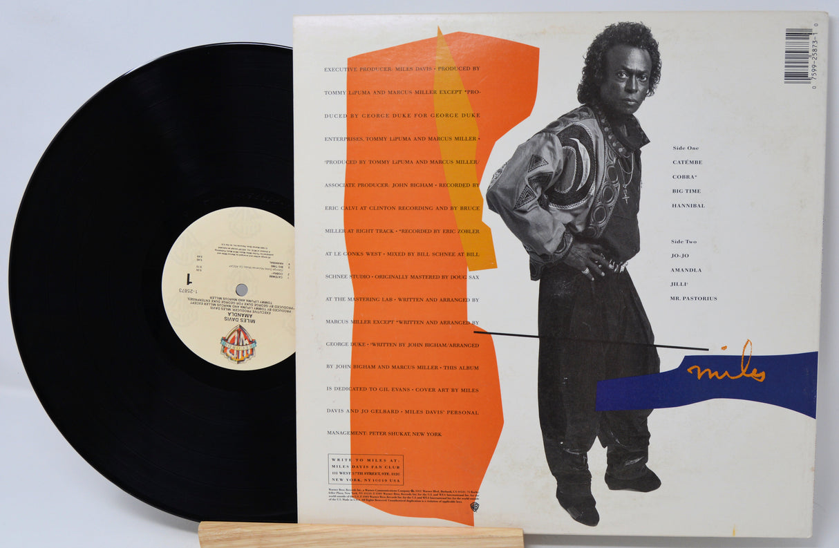 Vinyl record with cover featuring a person and abstract design on a light gray background