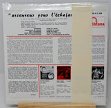 A vintage French movie program booklet for the film 'Ascenseurs pour l'échafaud' (Towers for the Dying) from 1963, displayed on a small wooden stand. The booklet features black text columns, two black-and-white photos of actors, and the red and white 'Montana' publisher logo at the top right.