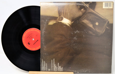 Vinyl record with a black disc and red label, and a cover featuring a person in a helmet.