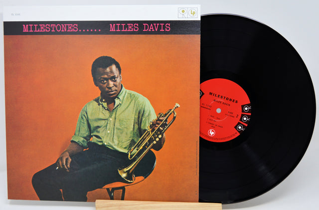 Miles Davis 'Milestones' vinyl record LP with the album cover standing to the left and the black record partially pulled out on the right, set against a clean white background.