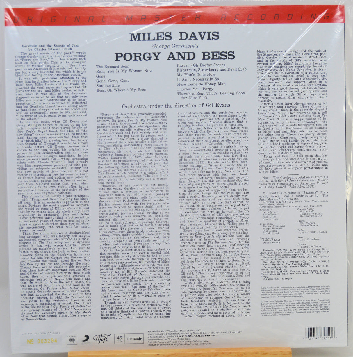 The back cover of a vinyl record sleeve for Miles Davis's 'Porgy and Bess' on Columbia Records, wrapped in protective plastic. The cover features a white background with black text, a red top banner.