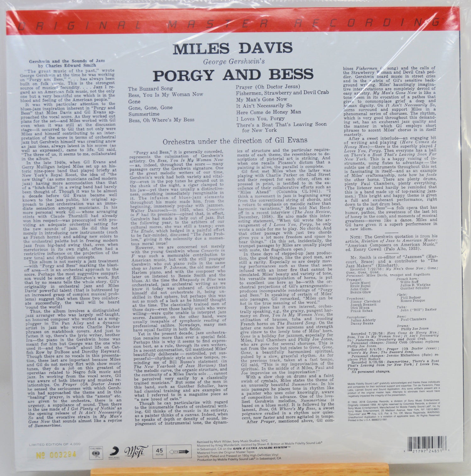 The back cover of a vinyl record sleeve for Miles Davis's 'Porgy and Bess' on Columbia Records, wrapped in protective plastic. The cover features a white background with black text, a red top banner.