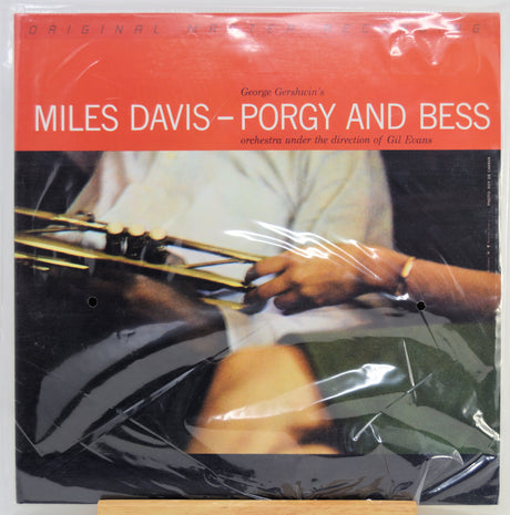 Miles Davis - Porgy and Bess album cover on a vinyl record, wrapped in protective plastic. The cover features a bright red-orange header with white text and a photograph.
