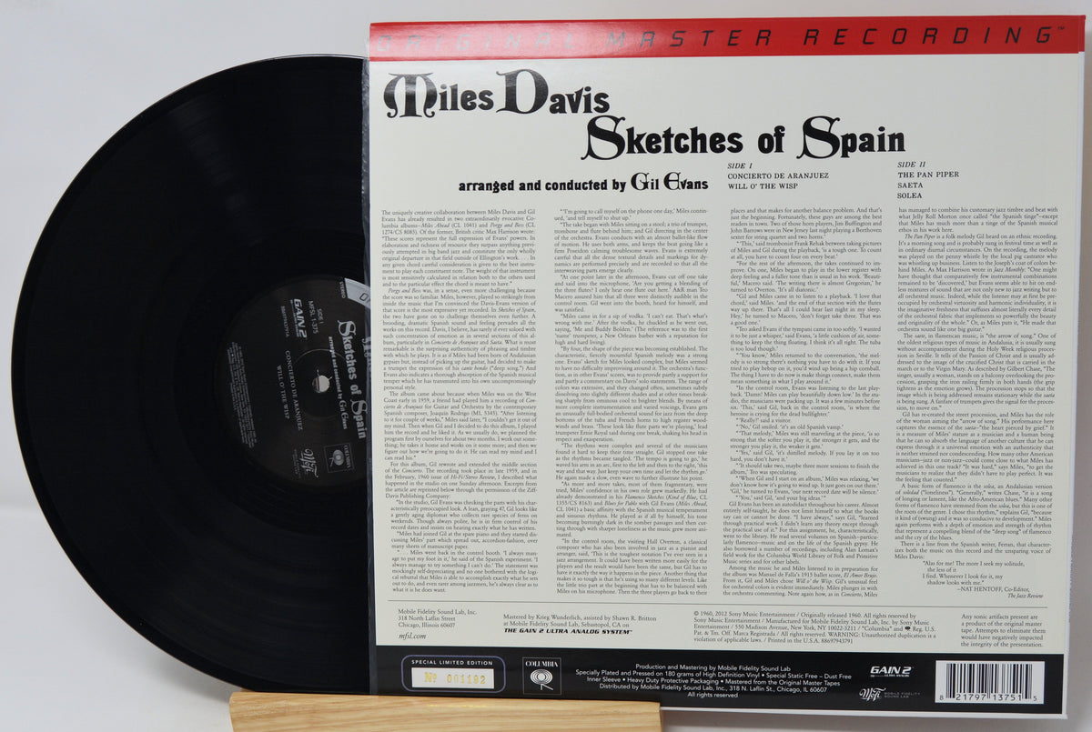 Miles Davis 'Sketches of Spain' vinyl record shown with the black LP partially pulled from the back of the record sleeve, photographed on a white background.
