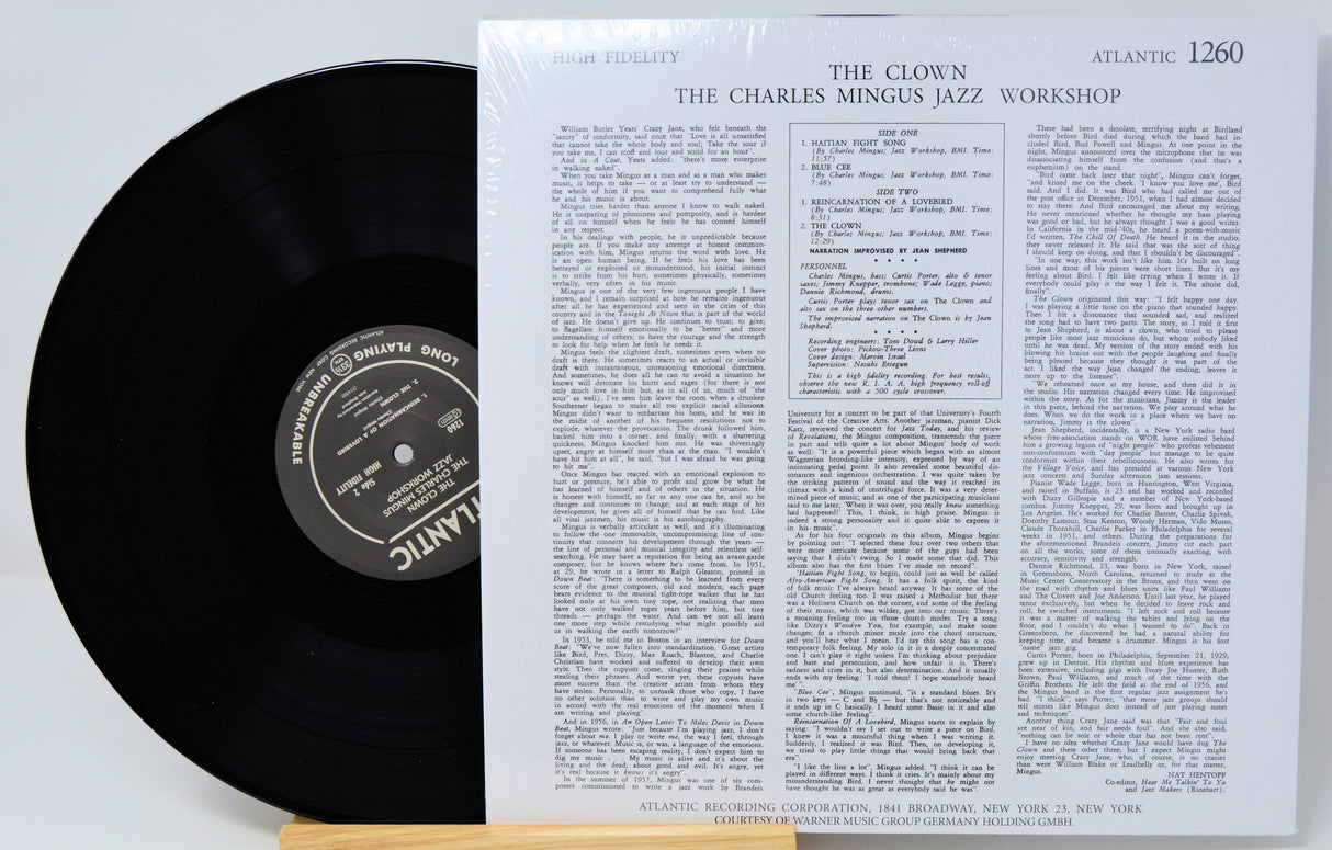 A vinyl record partially pulled from its sleeve, showing the black record and the printed cover insert for Atlantic's 'The Clown: The Charles Mingus Jazz Workshop'.