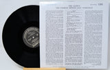 A vinyl record partially pulled from its sleeve, showing the black record and the printed cover insert for Atlantic's 'The Clown: The Charles Mingus Jazz Workshop'.