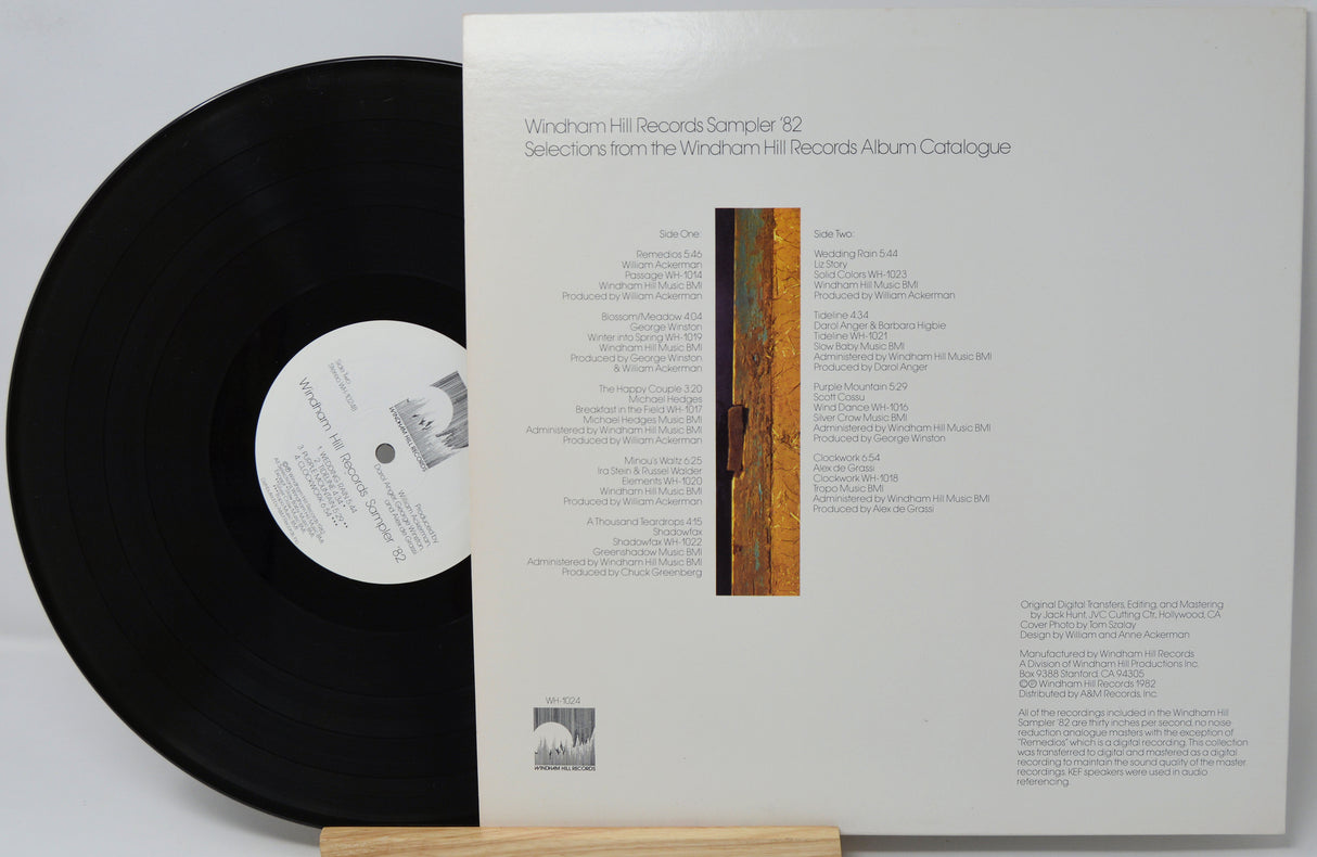 Vinyl record with its cover displaying text and a logo on a light gray background