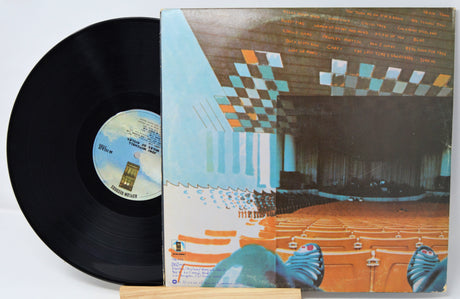 Vinyl record with a colorful album cover depicting a theater interior.