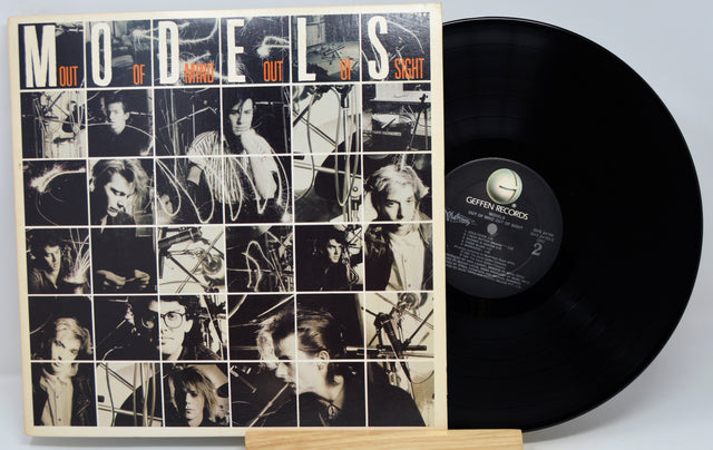 Vinyl record with cover featuring black and white images and text 'Models Out of Sight' on a light gray background.