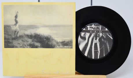 Vinyl record with a yellow cover featuring a black and white image of a person on a hill.