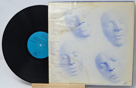 Vinyl record with a blue label and cover featuring artistic faces.