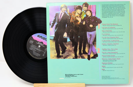 Vinyl record with cover featuring a band and text on a white background