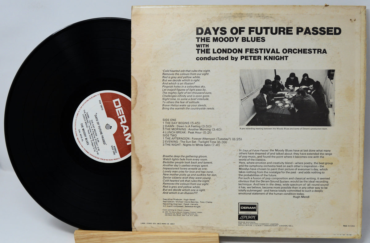 Vinyl record album shown with the black record partially pulled from the back cover, which reads 'DAYS OF FUTURE PASSED' and includes track listings and a small black-and-white photo on an aged cream paper background.