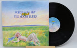 Used vinyl record of Moody Blues - Voices In The Sky with a record cover featuring an illustration of a person relaxing on grass under a blue sky, next to a vinyl record.