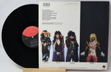 Vinyl record with a colorful cover featuring band members and text.