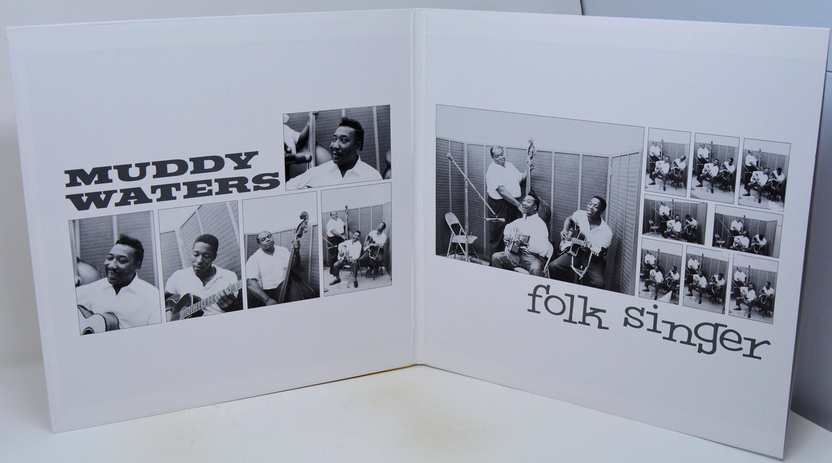 A white printed booklet or photo collage spread open on a light surface, showing black-and-white photographs and the text 'MUDDY WATERS' on the left page and 'folk singer' on the right page.