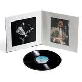 Vinyl record with a white cover featuring black and white photos of musicians playing guitar.