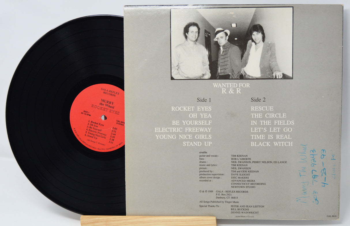 Vinyl record with cover featuring a black and white photo of three people and text.