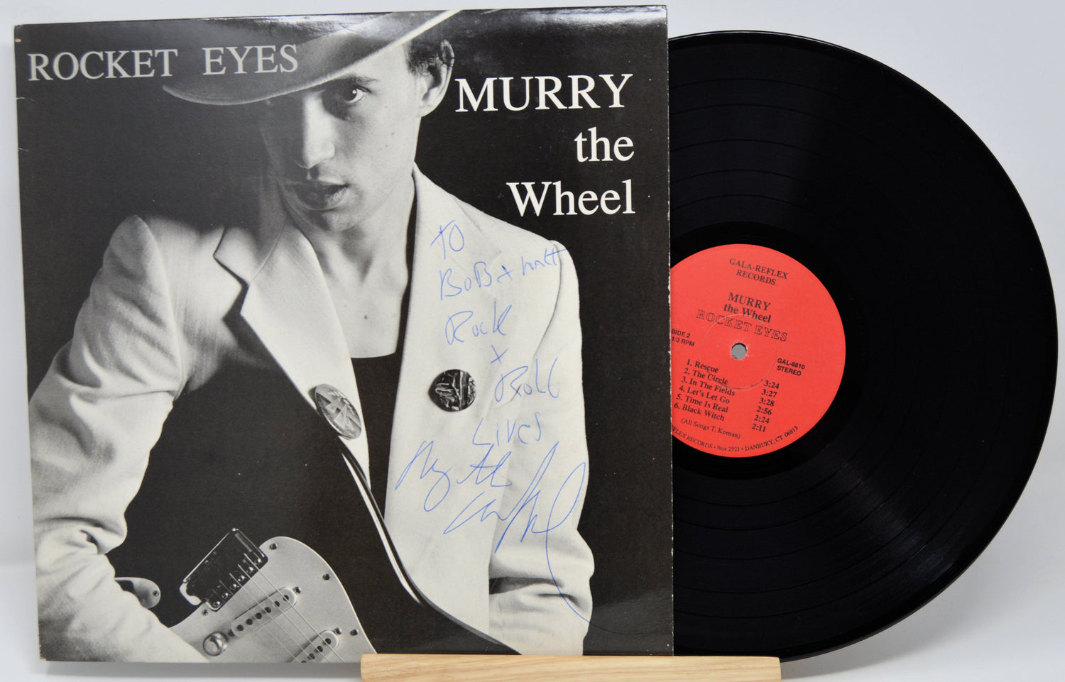 Vinyl record with cover featuring a person holding a guitar, titled 'Rocket Eyes Murry the Wheel'.
