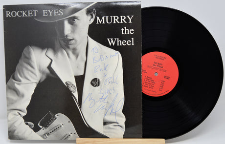 Vinyl record with cover featuring a person holding a guitar, titled 'Rocket Eyes Murry the Wheel'.