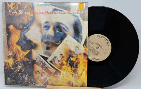 Vinyl record with a colorful cover featuring a face and flames, on a white background.