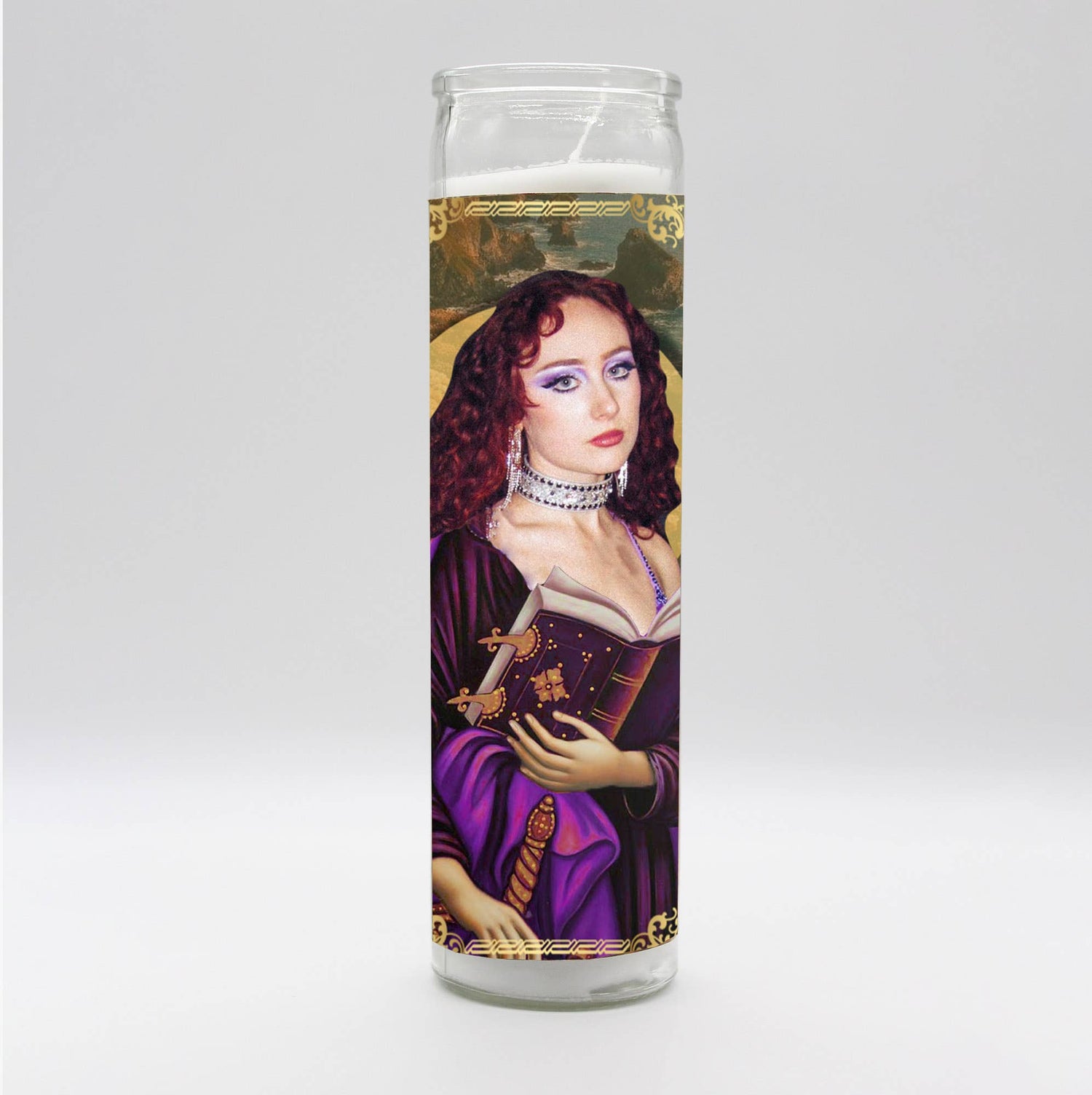 Decorative candle featuring a mystical woman in purple holding a spellbook and a jeweled sword