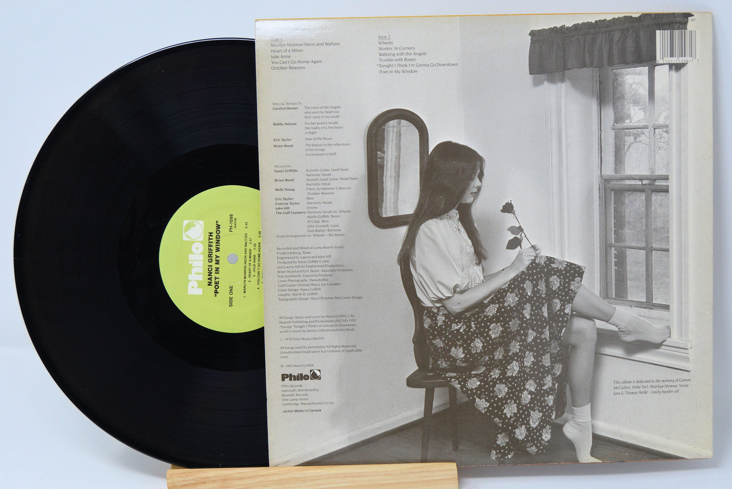 Back cover of Nanci Griffith's 'Poet in My Window' vinyl LP featuring tracklist and grayscale photo of Nanci by a window