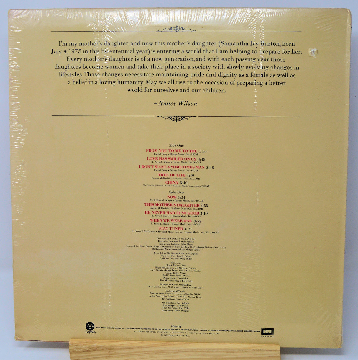 Back cover of a vinyl record with text and tracklist on a beige background