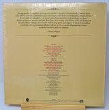 Back cover of a vinyl record with text and tracklist on a beige background