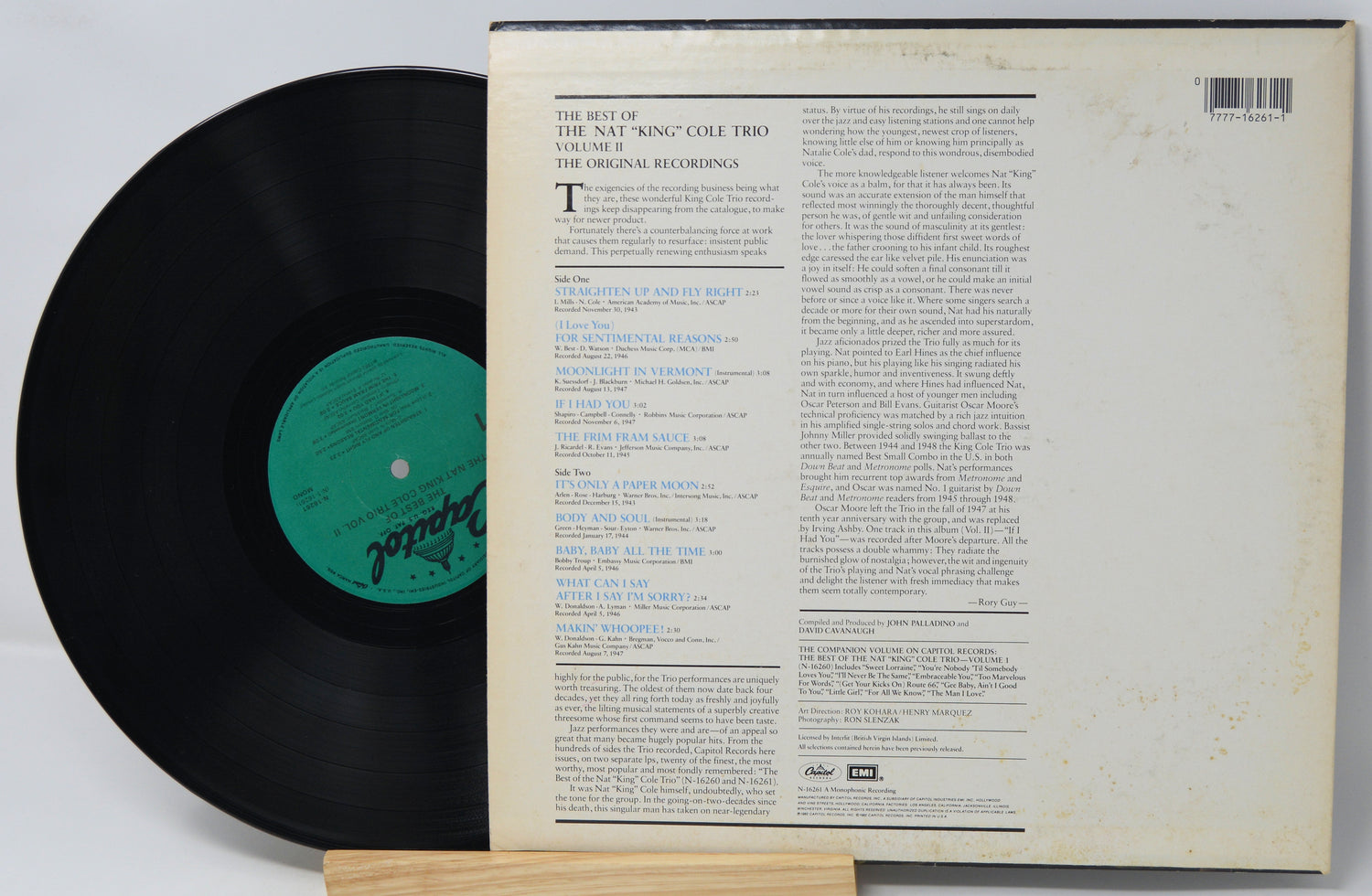 Vinyl record with its cover displaying text on a light gray background