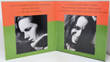 A book or album cover shown open, with two front panels visible. The design has a bright orange top section and a lime green bottom section, with black-and-white portrait photos of a woman and white title text.