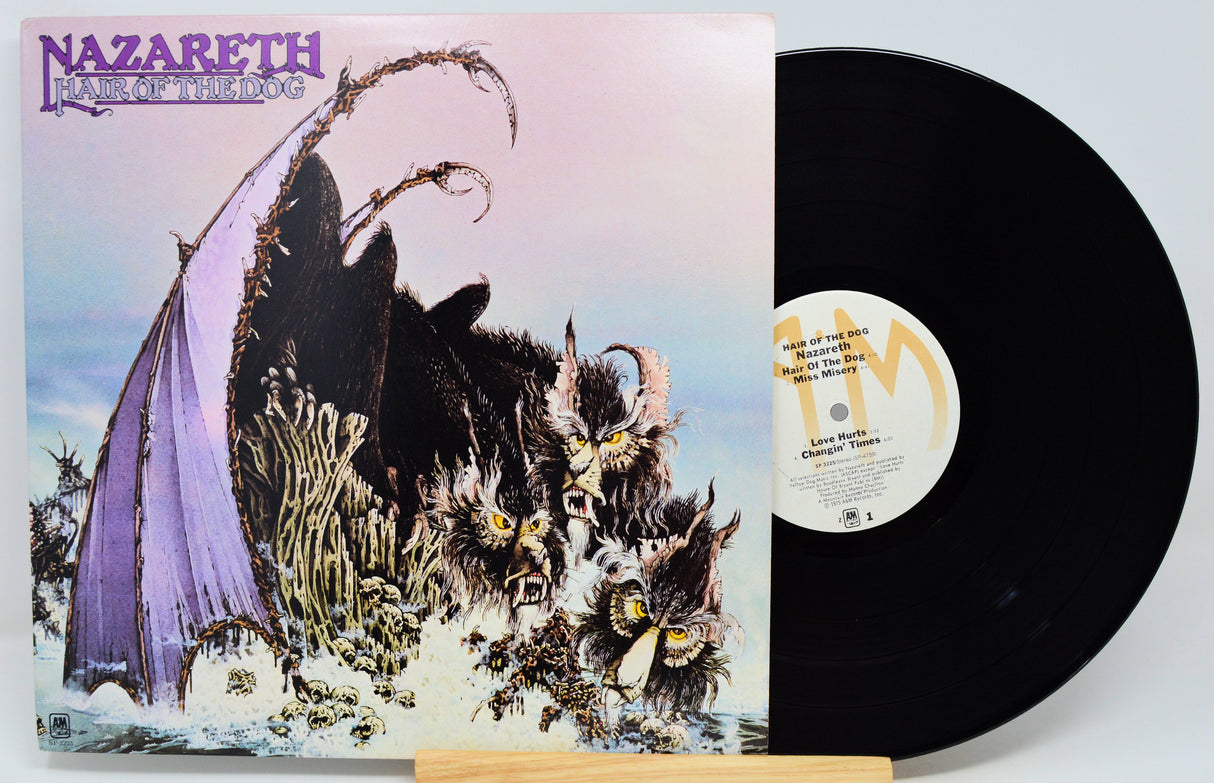 Nazareth - Feast of the Lamb vinyl record LP with the illustrated album cover standing beside the black record on a light background.