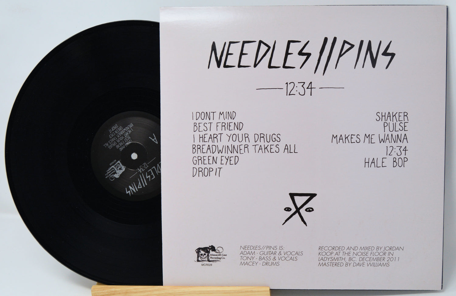 Vinyl record with 'Needles//Pins' album cover on a light gray background