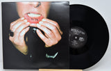 Vinyl record with a person holding their face on the cover