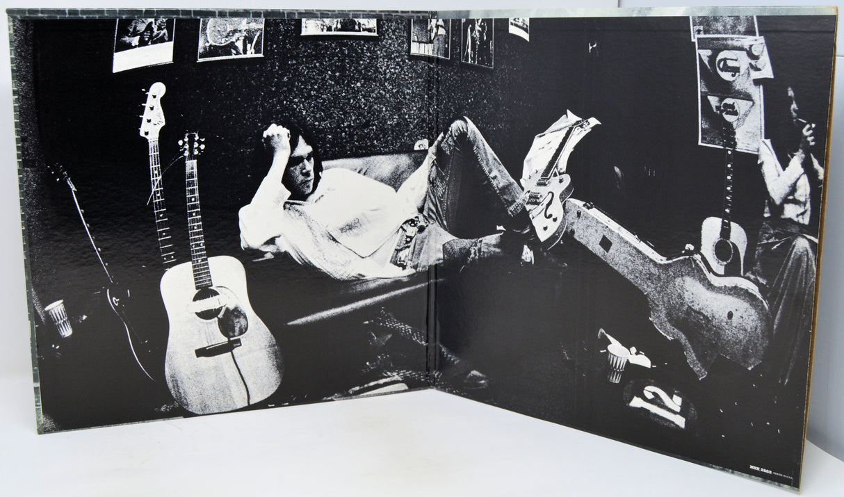 Album cover with a person lying on a couch with guitars, surrounded by smaller images of people and guitars.