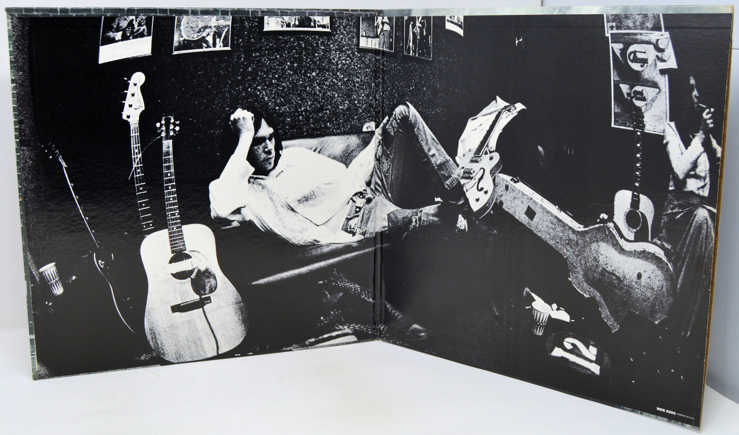 Album cover with a person lying on a couch with guitars, surrounded by smaller images of people and guitars.
