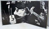 Album cover with a person lying on a couch with guitars, surrounded by smaller images of people and guitars.