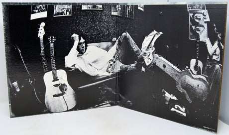 Album cover with a person lying on a couch with guitars, surrounded by smaller images of people and guitars.