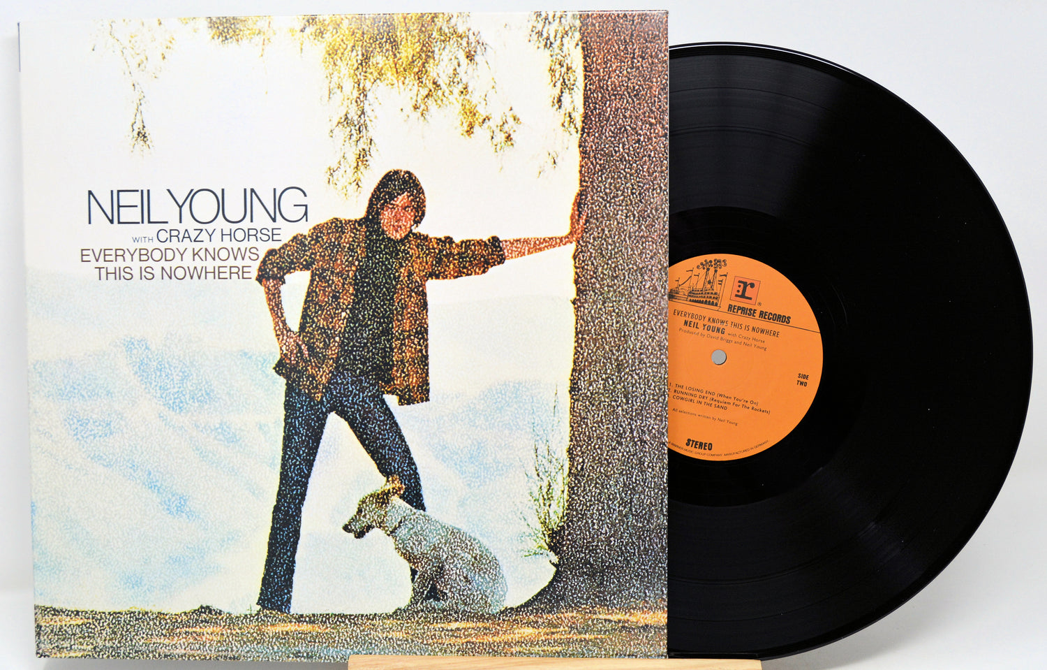 Neil Young's 'Crazy Horse' vinyl record LP with its illustrated cover jacket and the black record partially pulled out, showing the orange center label.