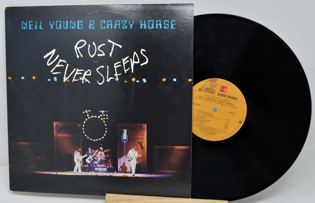 Vinyl record with its cover featuring a guitar on a rocky background, titled 'Looking Back' by John Mayall.