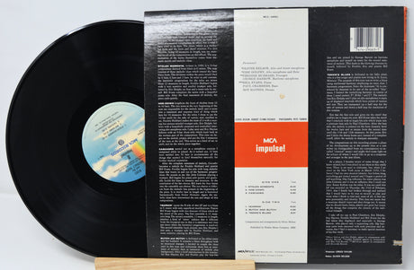 Vinyl record with its cover displaying text and a logo on a white background