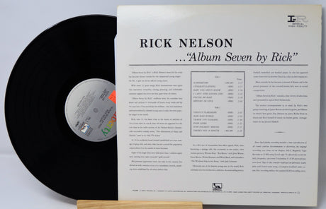 Vinyl record with its cover displaying 'Rick Nelson Album Seven by Rick' on a light gray background.