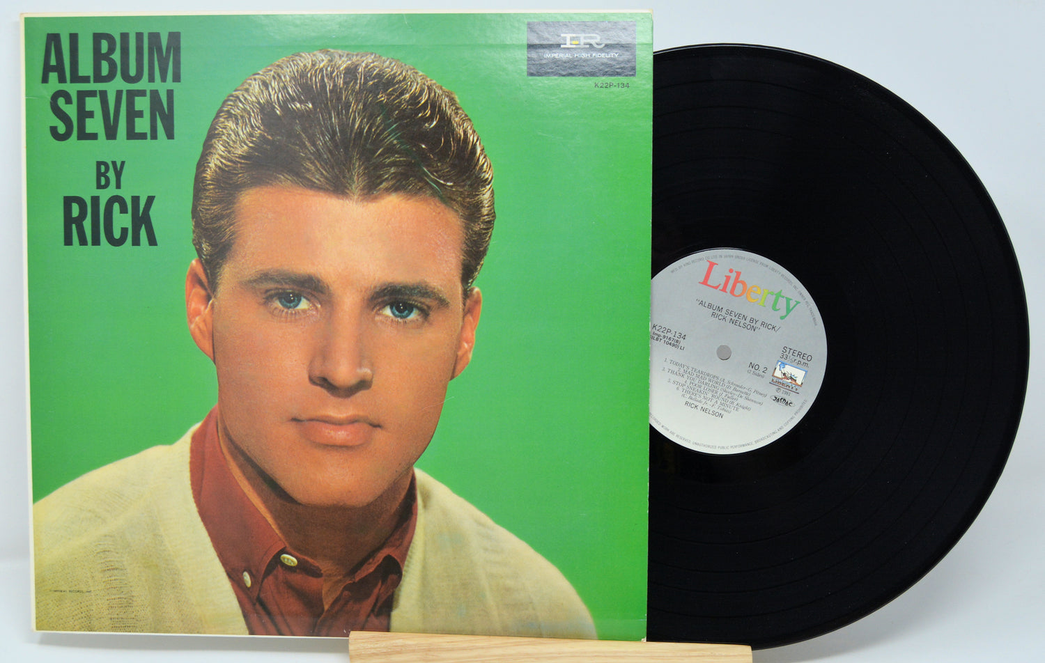 Vinyl record with green album cover featuring a person's portrait and 'Album Seven by Rick' text.
