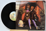Vinyl record with a colorful cover featuring people and a woman's face.