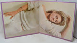 Open book showing a woman wearing a white knitted sweater on a plain background