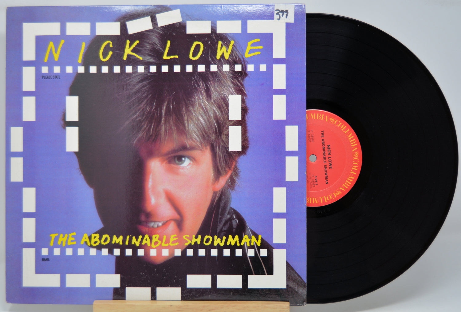Vinyl record with cover featuring a person's face and 'Nick Lowe The Abominable Showman' text.