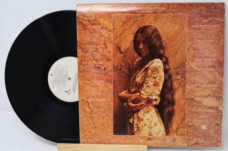 Vinyl record with a cover featuring an image of a person and text on a light gray background